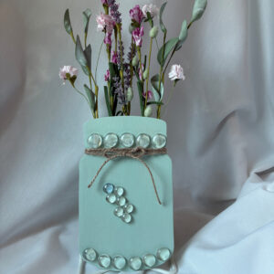 An art piece consisting of a wooden jar with dried flowers.